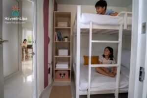 Kids playing in a bunk room while grandparents relax nearby at a Lipa City family house rental